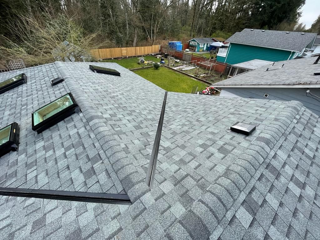 A roof with a vent on it and a building in the background.