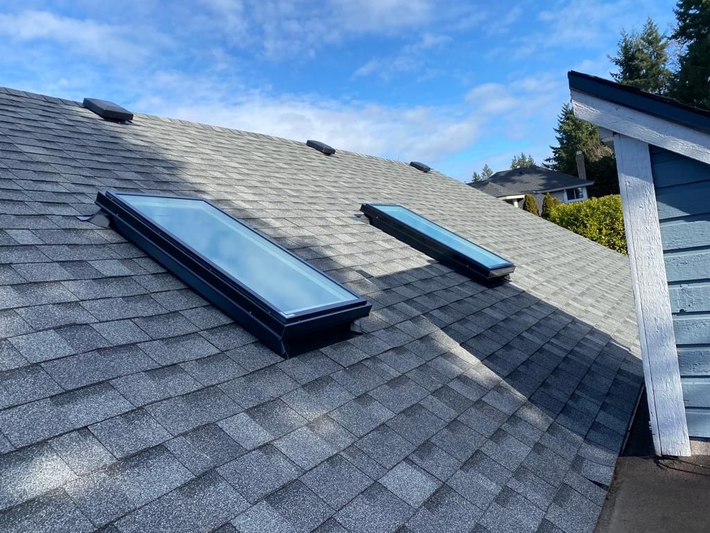 There are two skylights on the roof of a house.