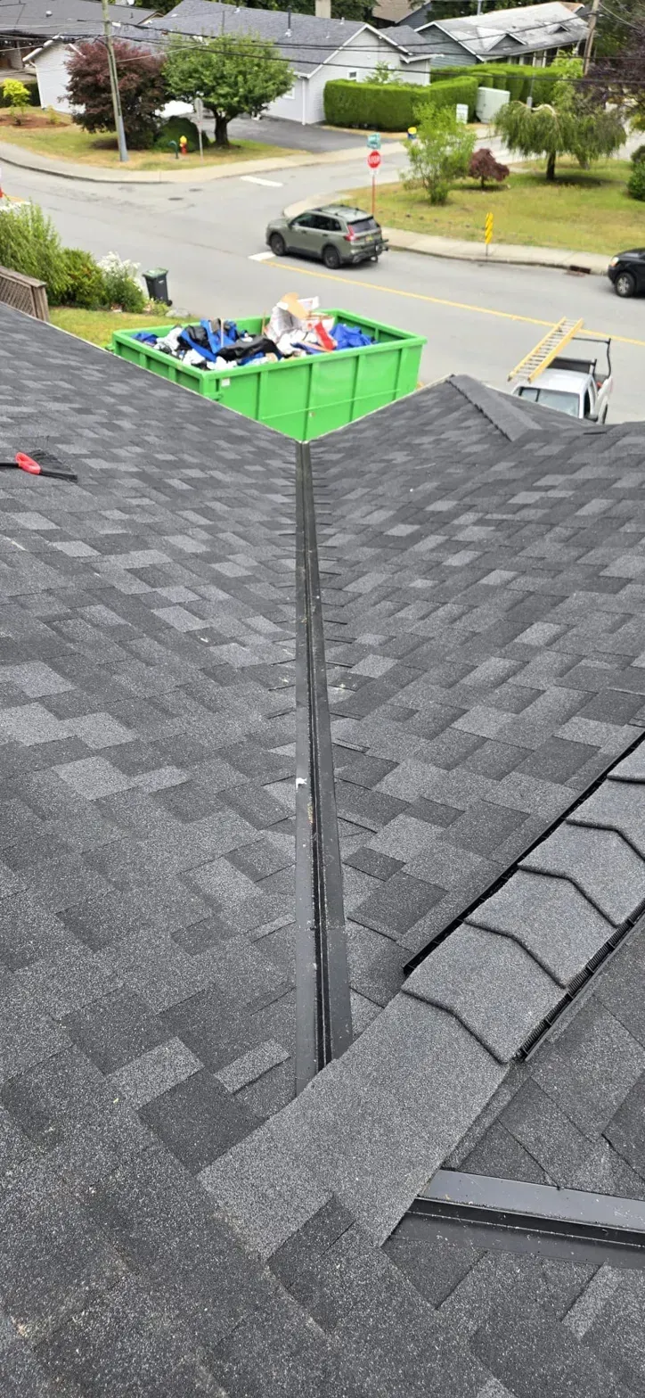 New black open metal valley between IKO Dynasty roof planes on Thermal Drive Coquitlam, Paragon Roofing BC