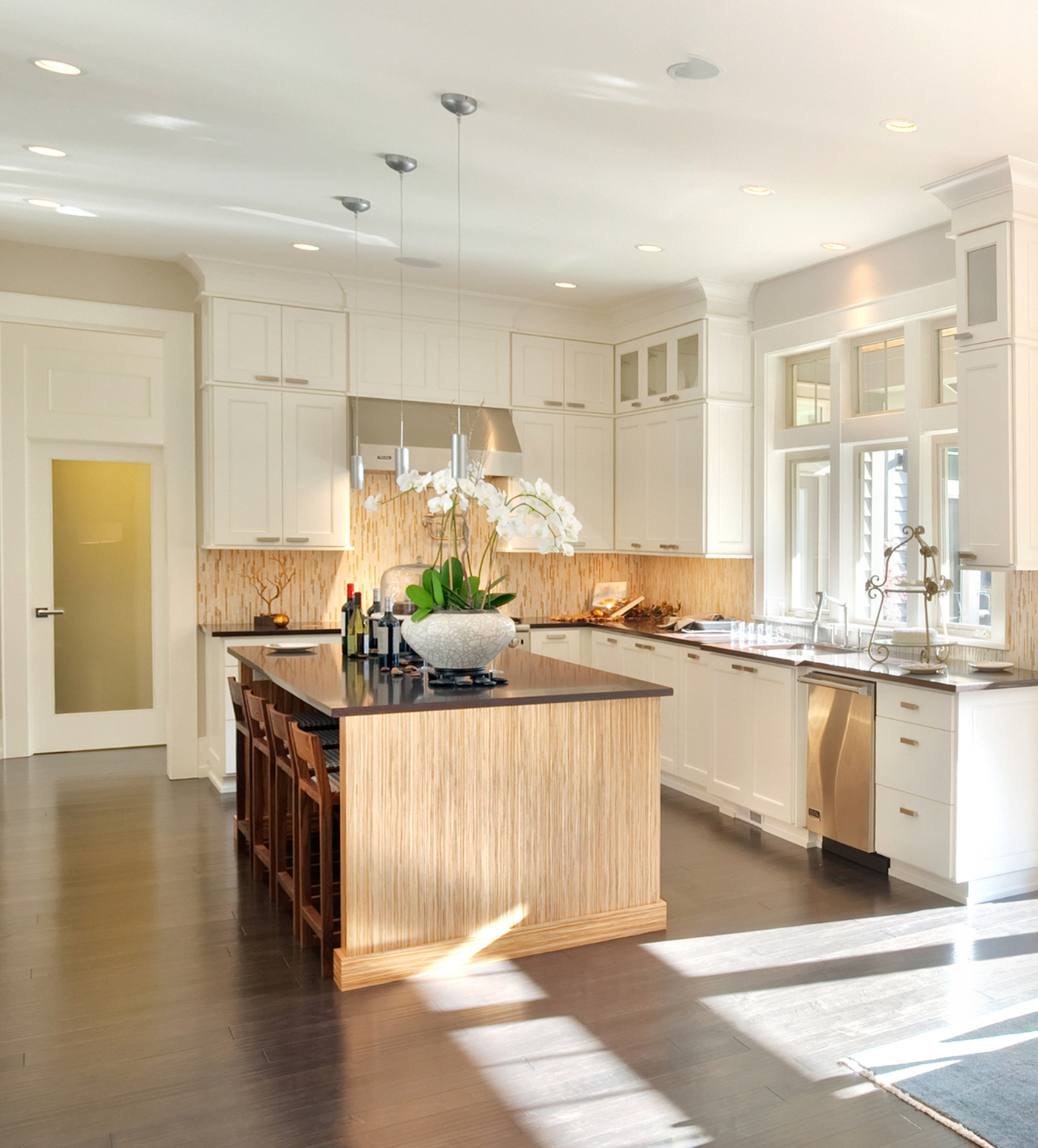 Bright modern kitchen with white cabinets, dark island, and sunlight streaming across the floor in Rockville