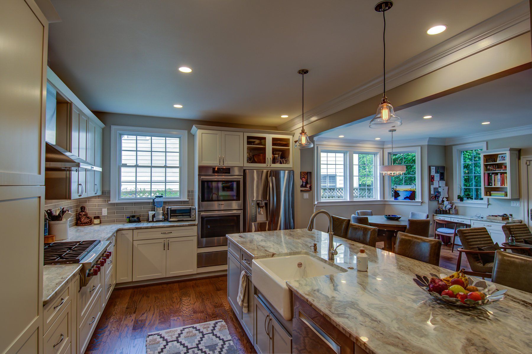 Bright modern kitchen with island, stainless appliances, pendant lights, and adjacent dining area in Gaithersburg