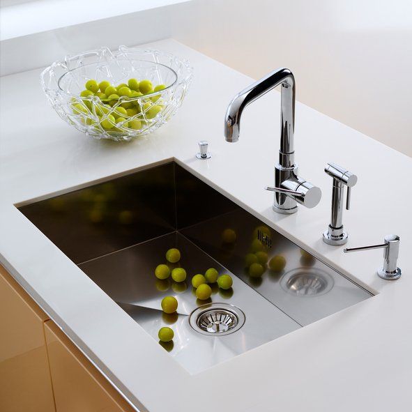 Modern white kitchen sink with chrome faucet and a bowl of green grapes on the counter in Rockville
