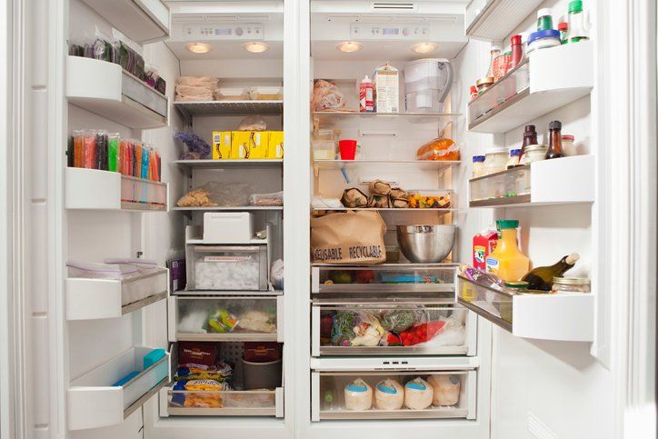 Open refrigerator with shelves of food, drinks, and condiments organized in a bright kitchen in Rockville