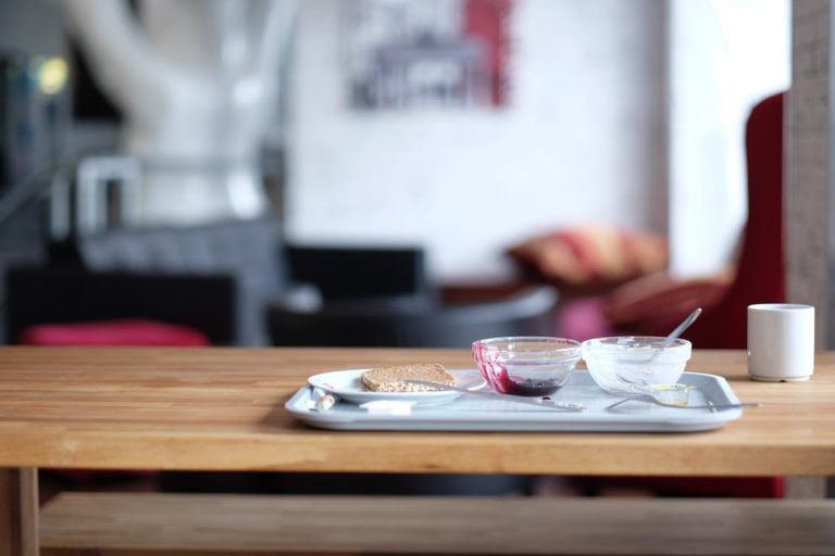 Tray with cups and a spoon on a wooden table in a blurred café interior in Rockville