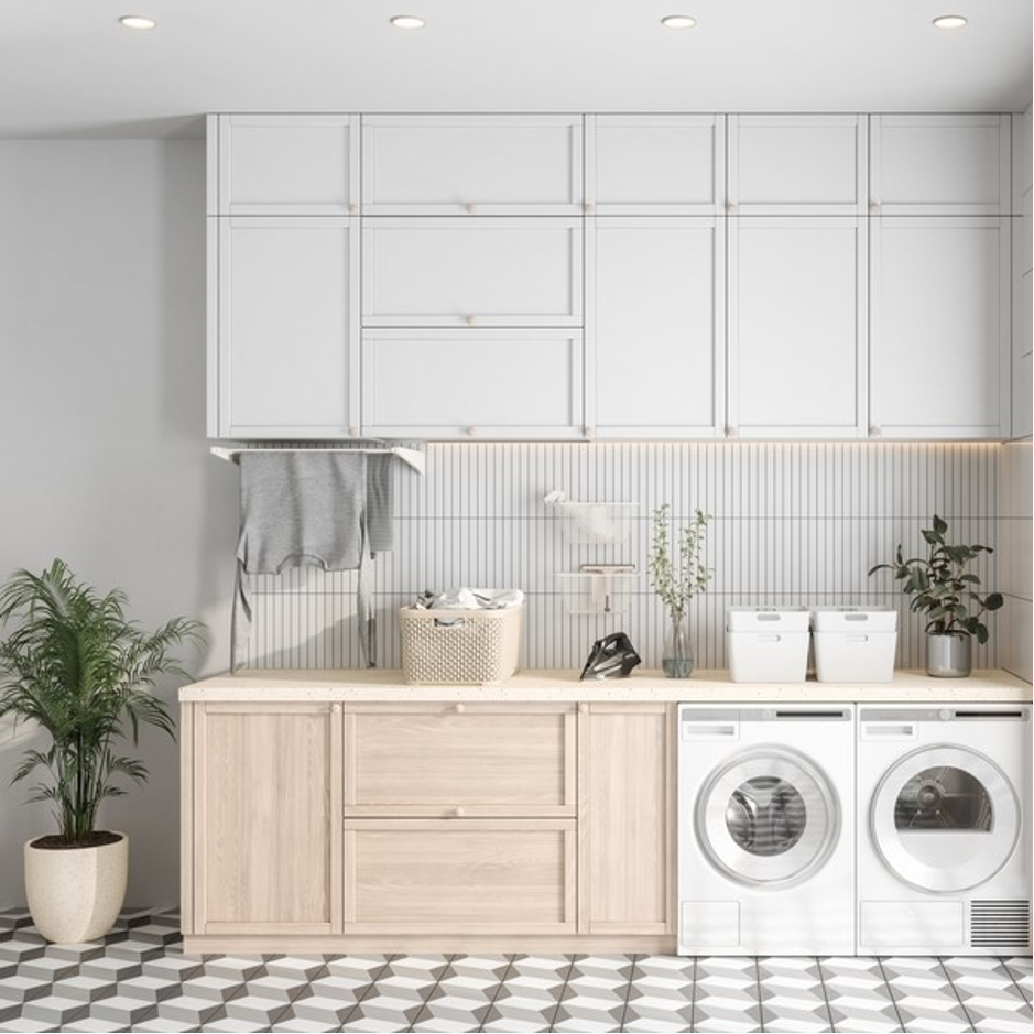Modern laundry room design with white cabinets, wooden storage, washer dryer setup, and patterned floor tiles