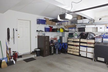 Garage with shelves, storage drawers, tools, skis, and a white door on the left  in Rockville