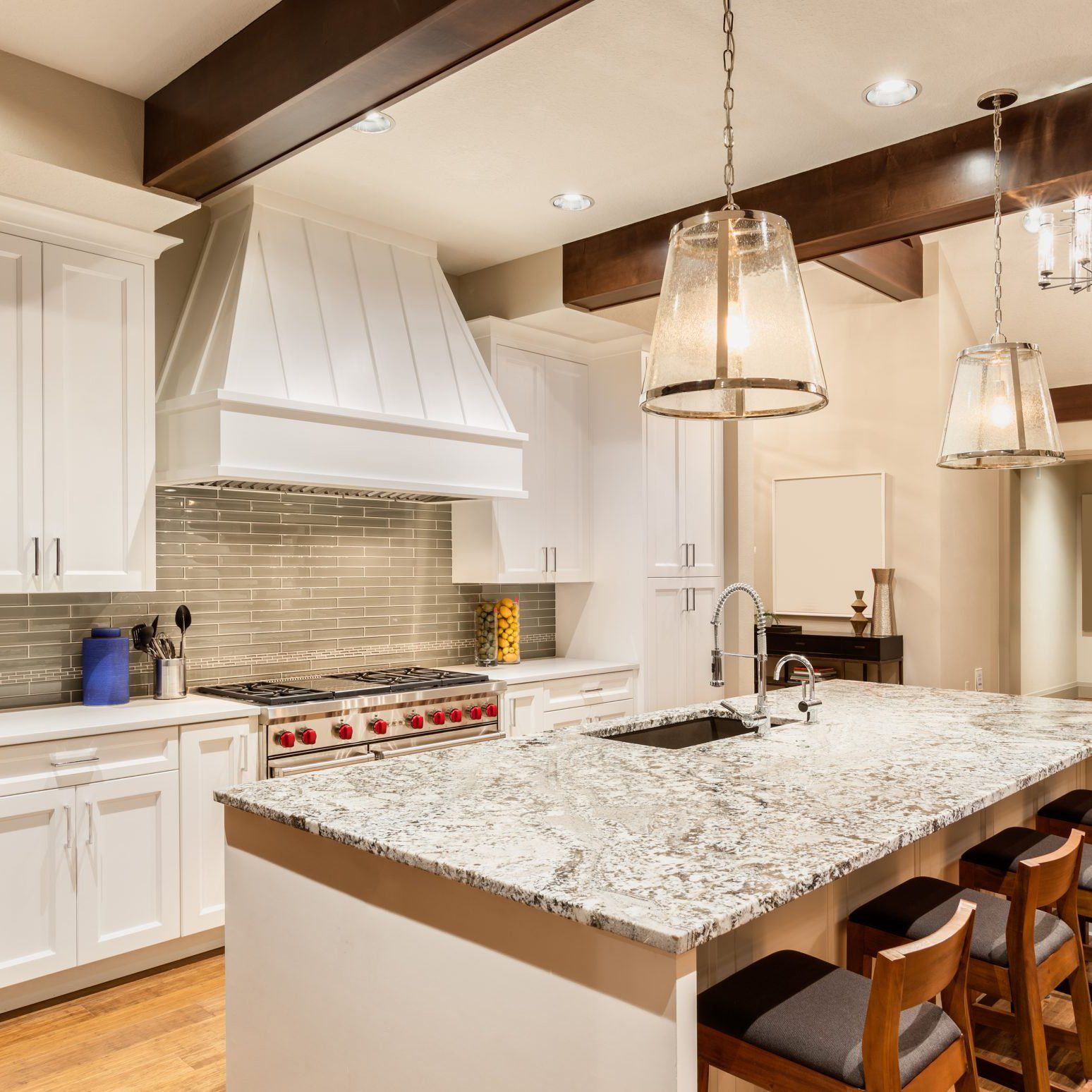 Bright modern kitchen with white cabinets, granite island, and pendant lights in Rockville