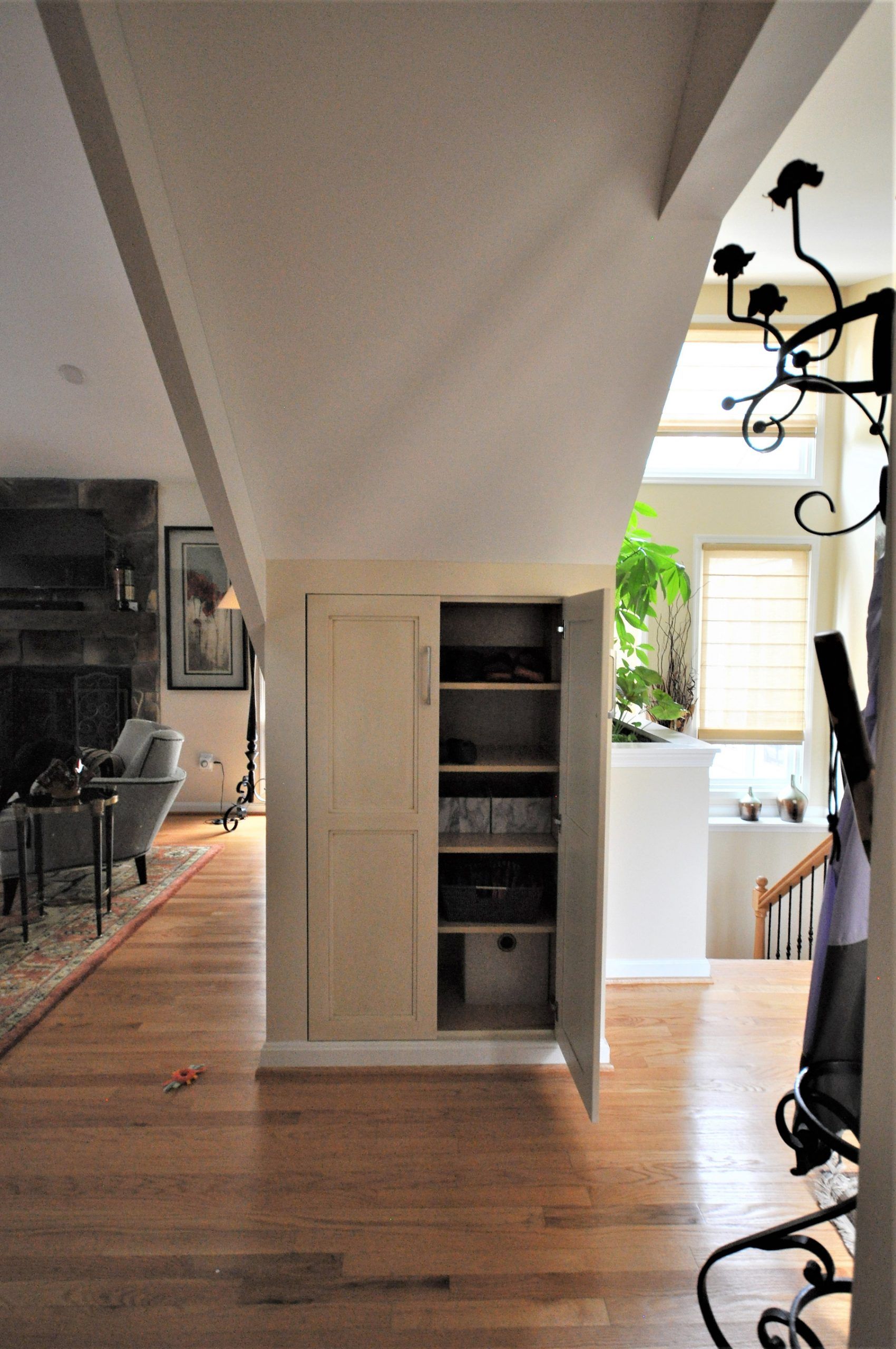 Hallway with wood floors, built-in shelving, and a bright opening to a kitchen area in Rockville