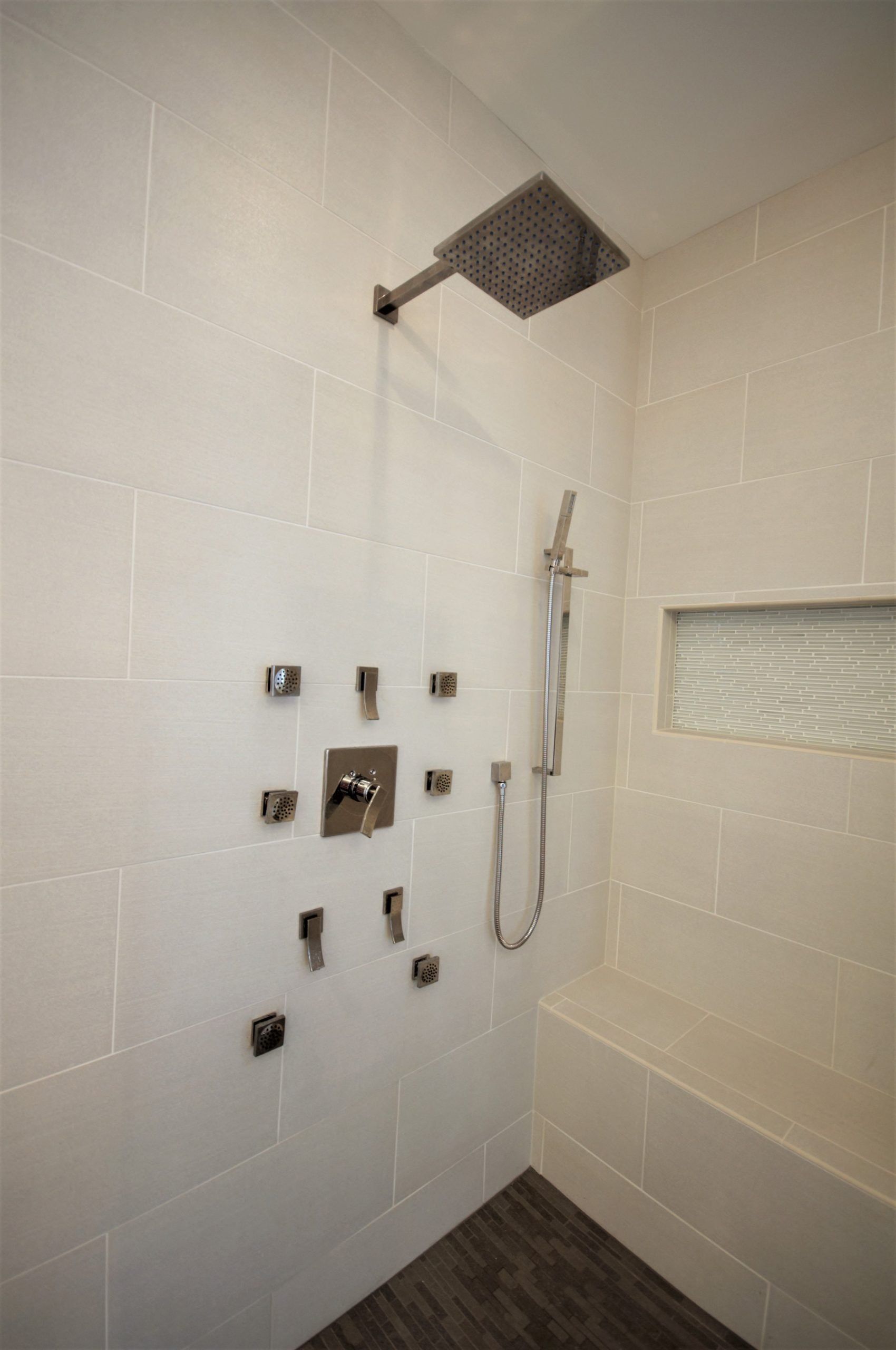 Modern tiled shower with rain head, handheld shower, and wall-mounted fixture holes  in Rockville