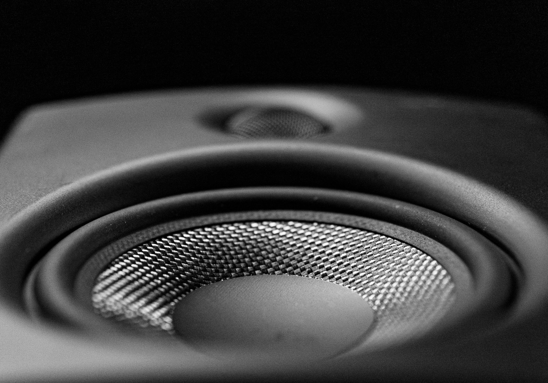 Close-up of a black speaker cone with textured metal center