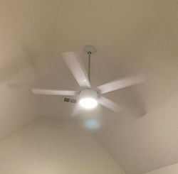 A white ceiling fan is hanging from the ceiling of a room.