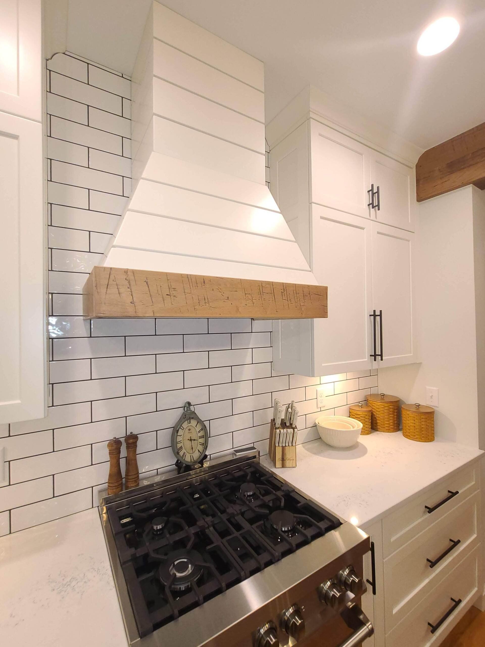A kitchen with a stove and a clock on the counter