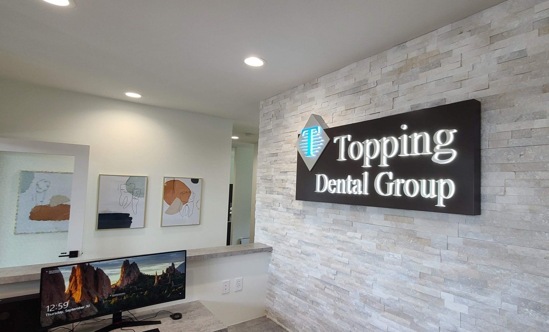There is a sign on the wall that says topping dental group.