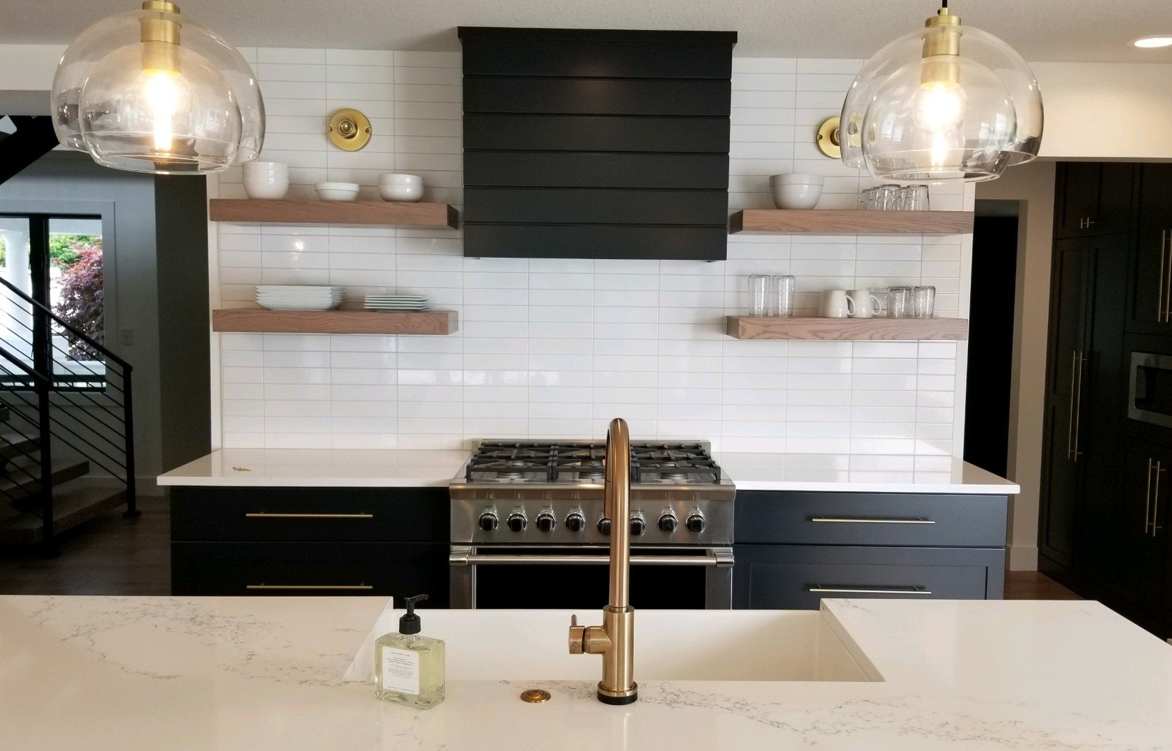 A kitchen with white cabinets , granite counter tops , stainless steel appliances and a large island.