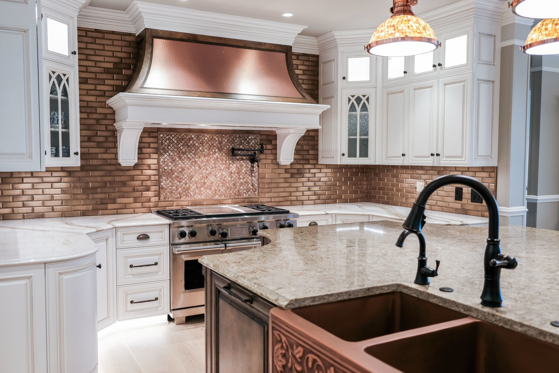 A kitchen with white cabinets and stools and a large island
