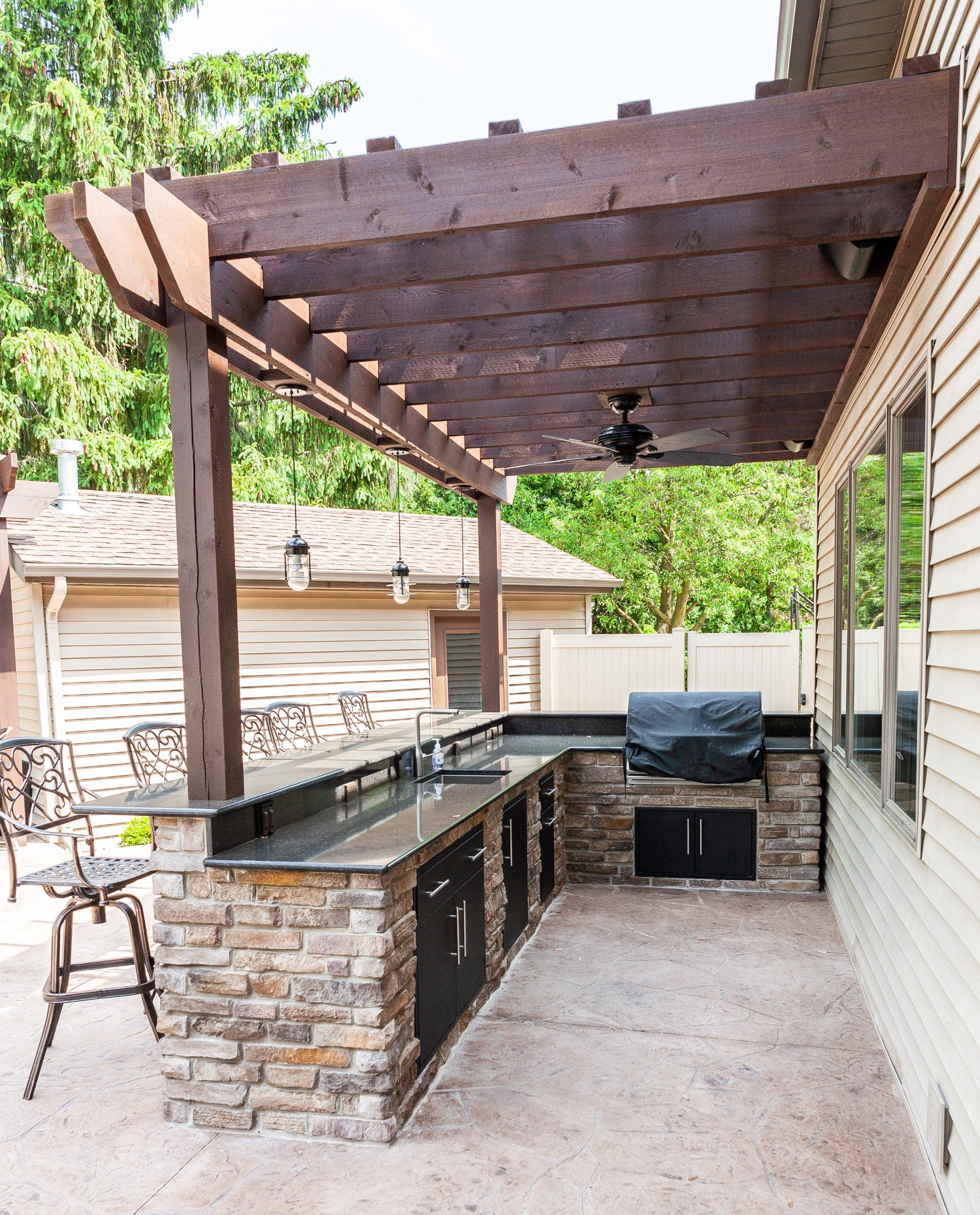 An outdoor kitchen with a pergola over it