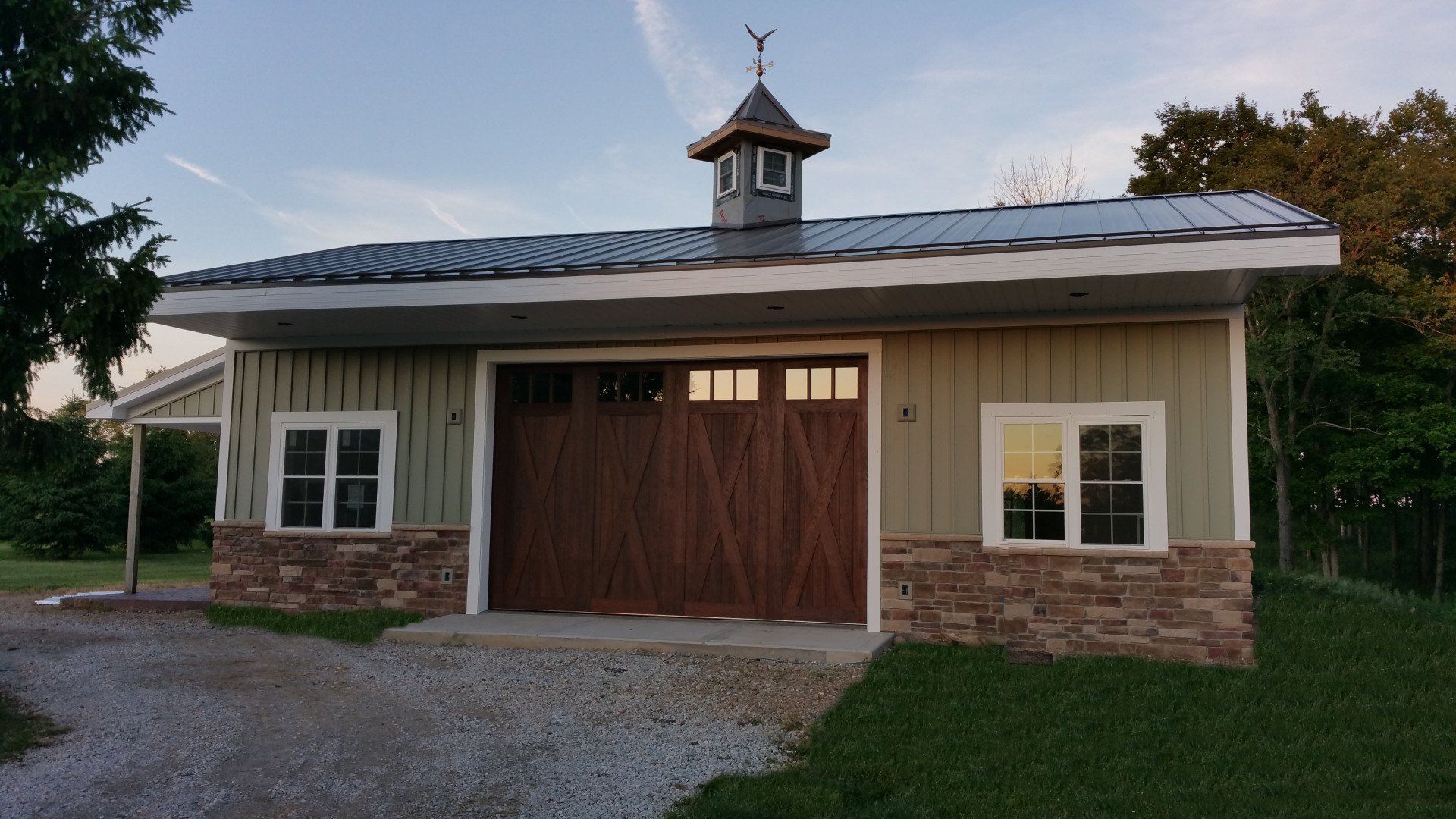 A garage with a wooden garage door and a metal roof.