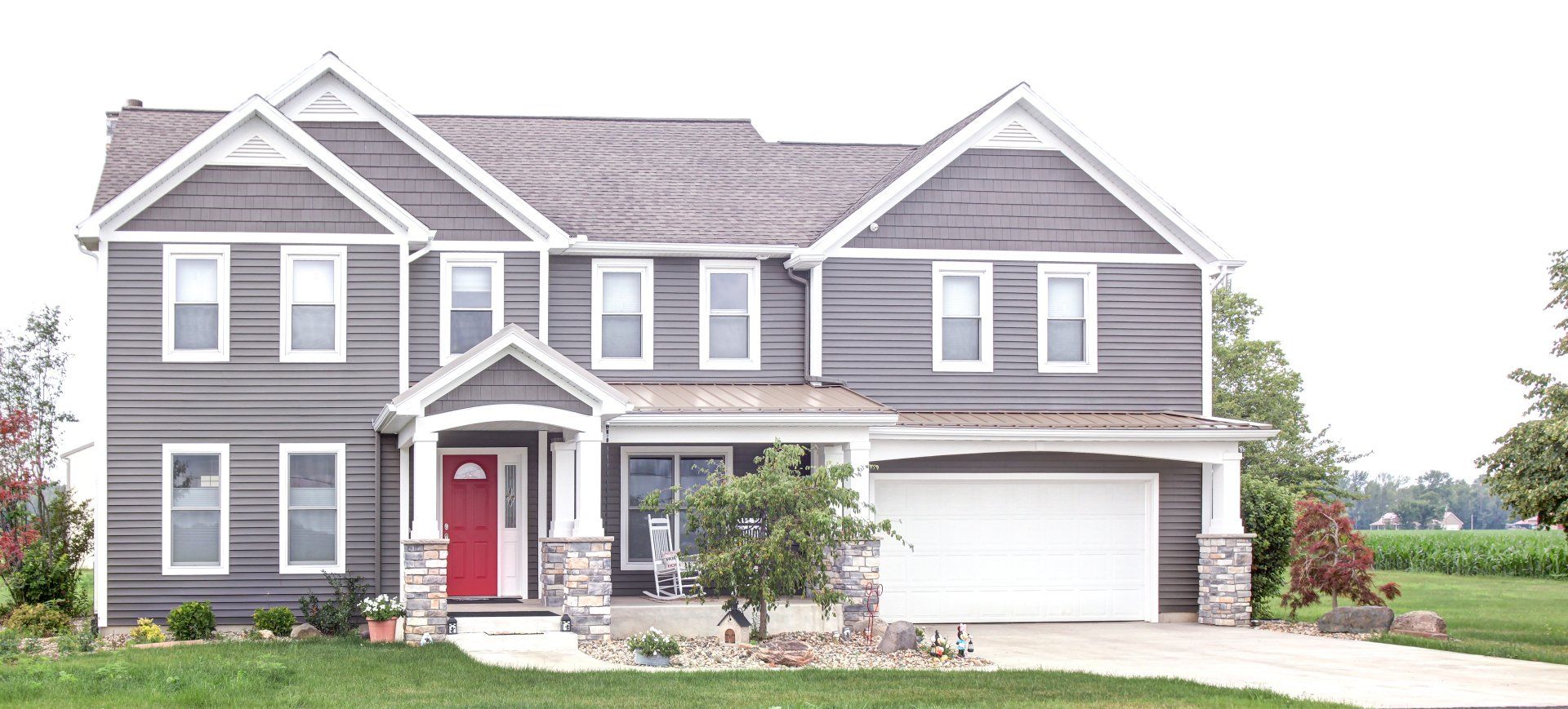 A large house with a red door and a white garage door.