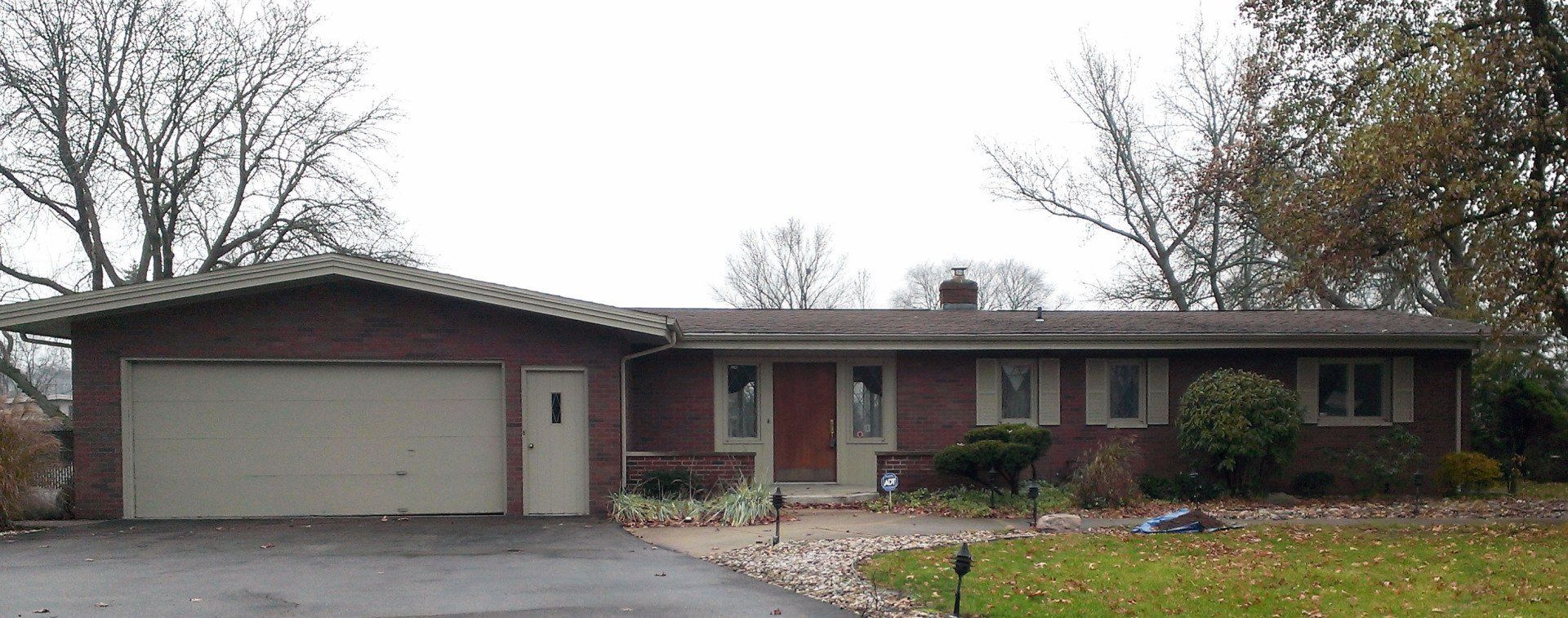 A red brick house with a white garage door