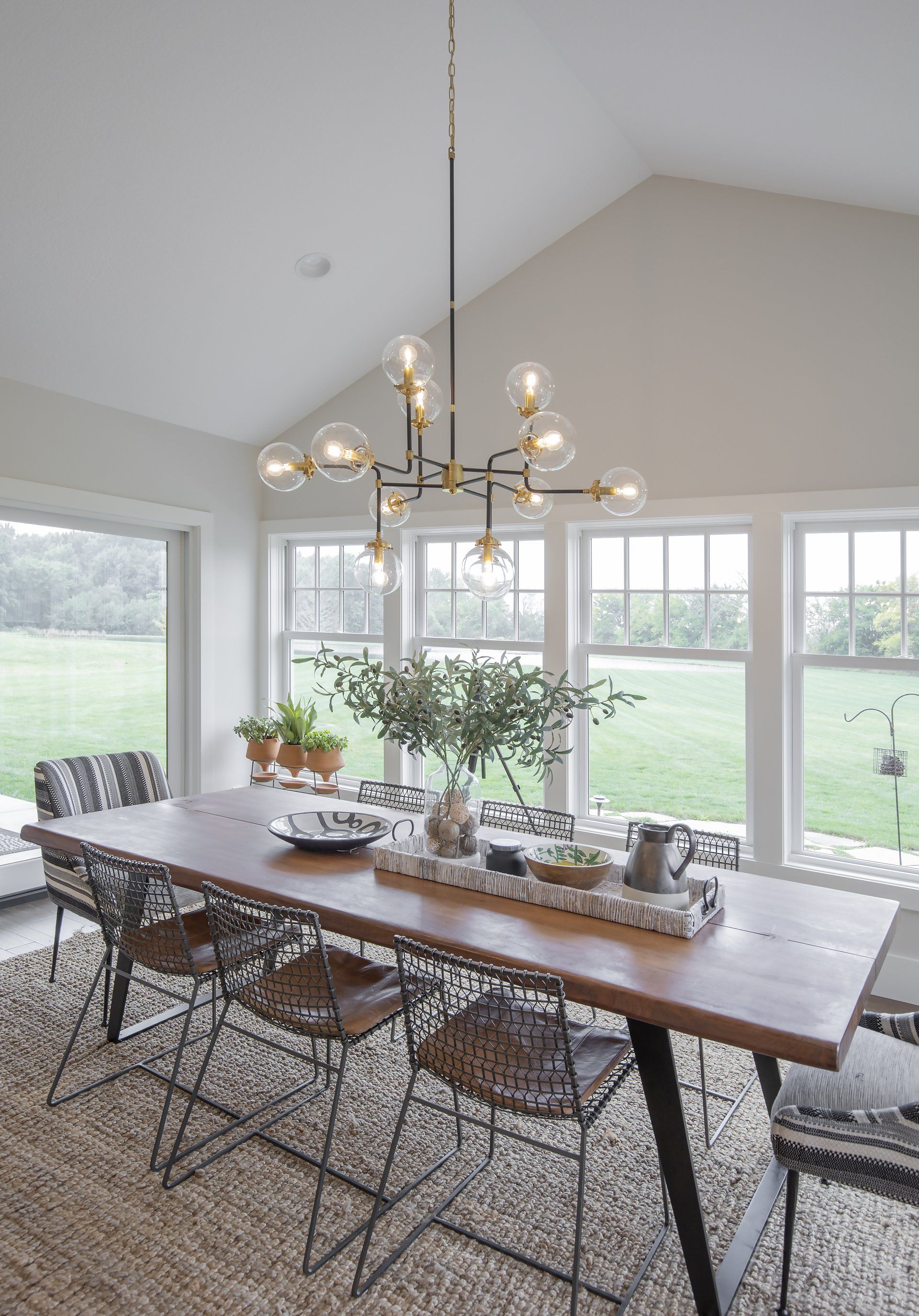 A dining room with a long wooden table and chairs and a chandelier.