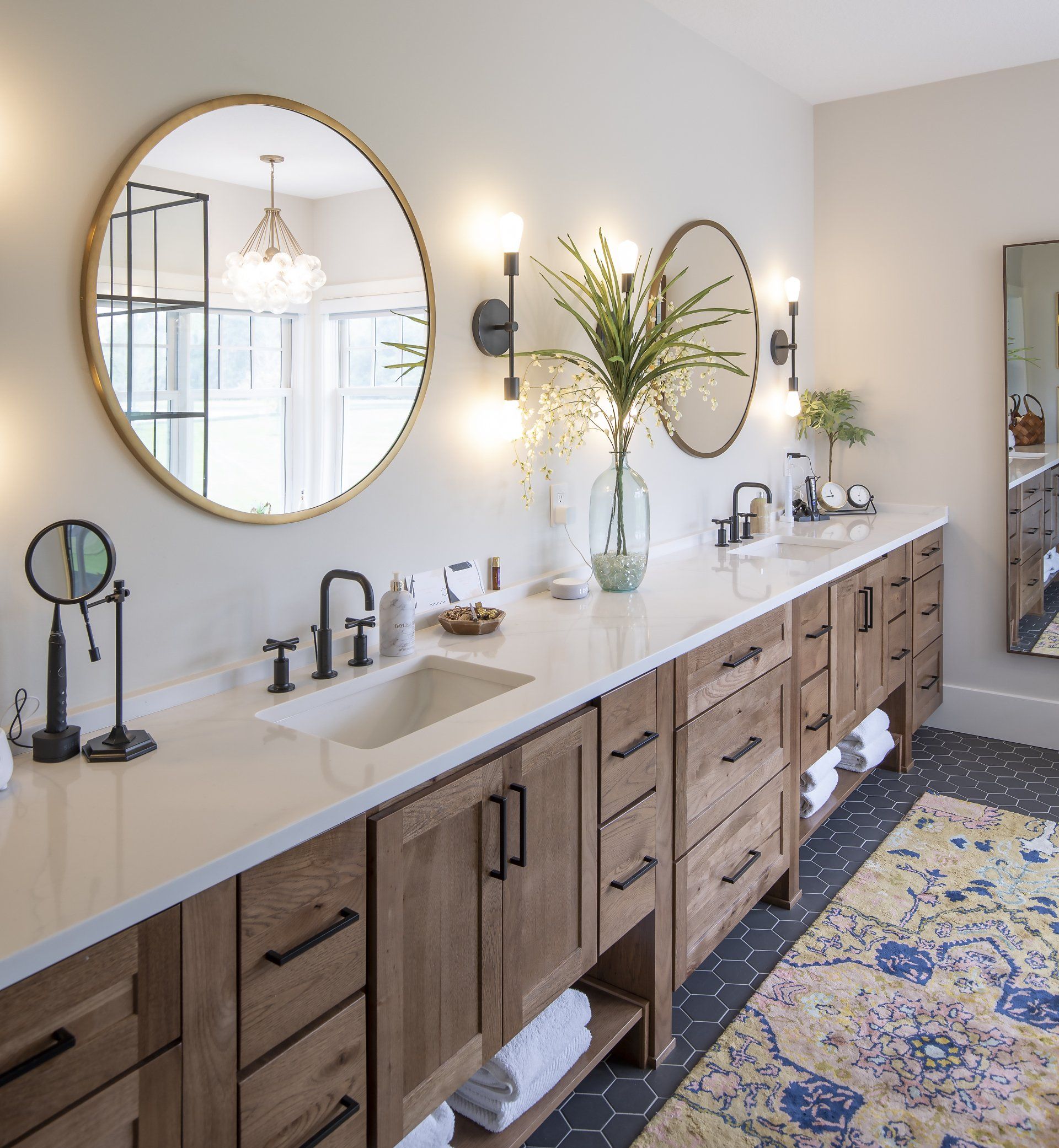 A bathroom with a sink and two mirrors on the wall
