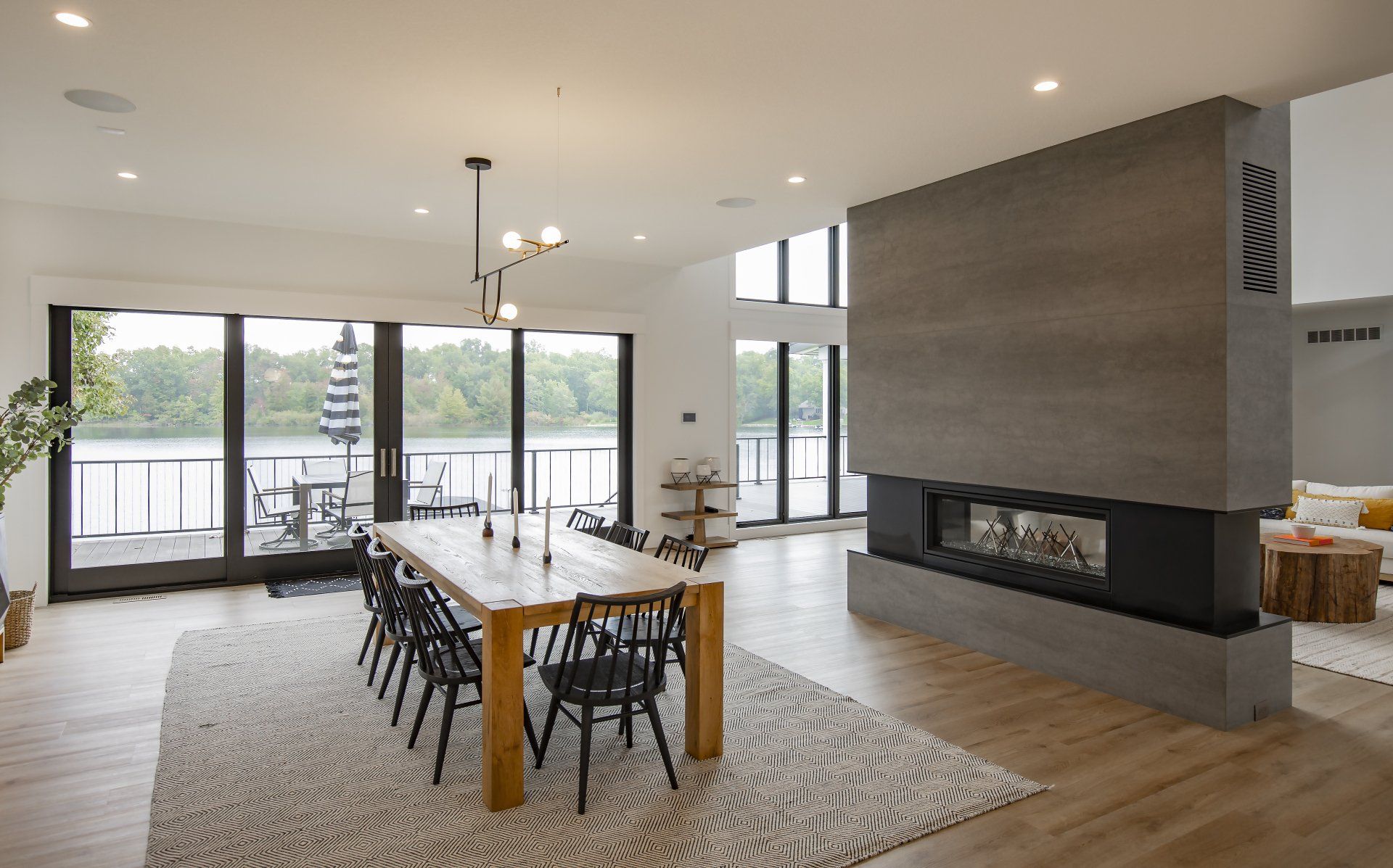 A large living room with a dining table and chairs and a fireplace.