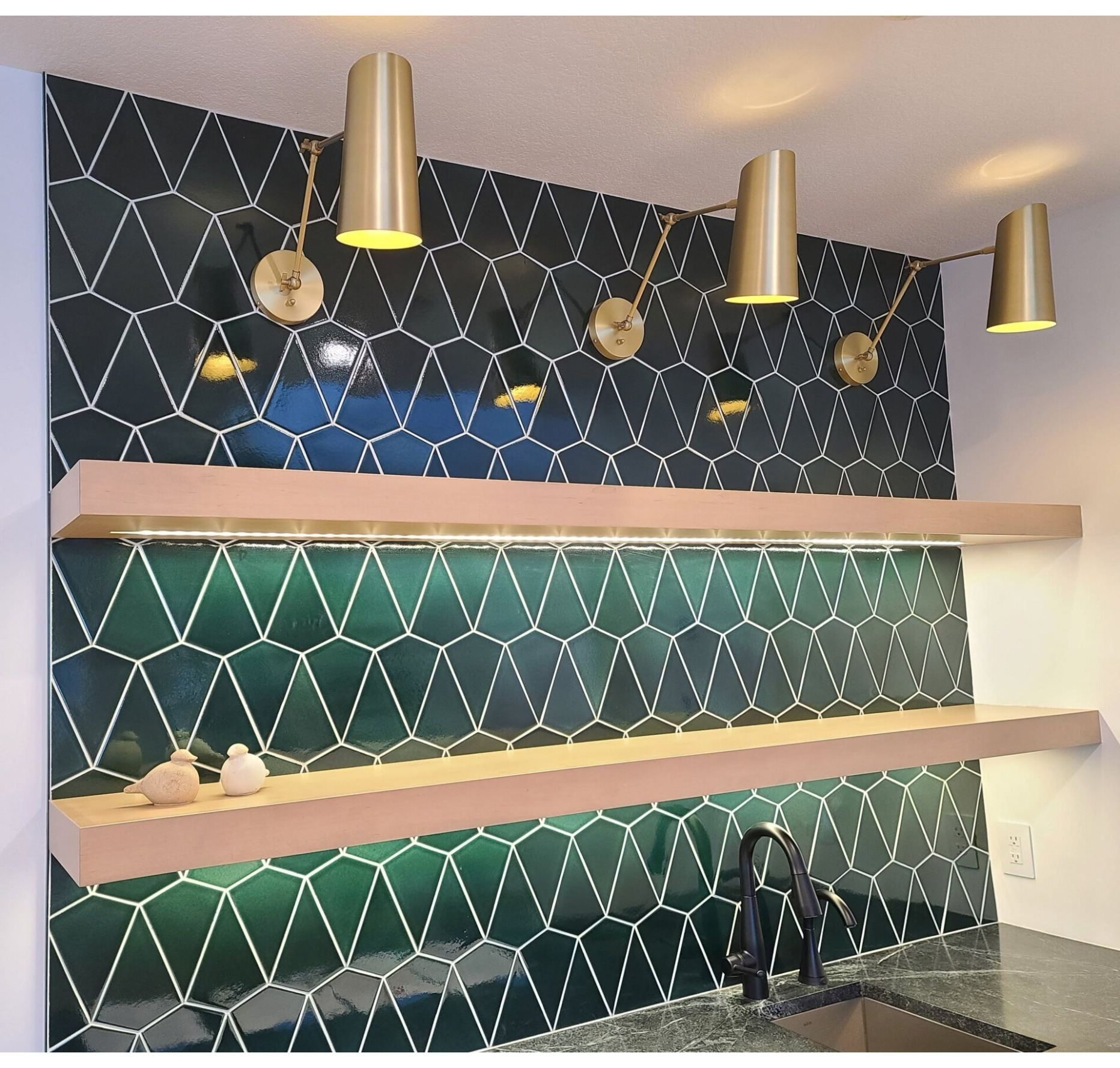 A kitchen with green tiles and a sink