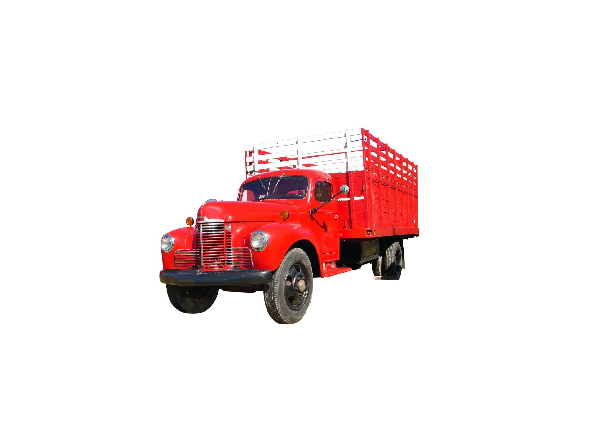 Classic red work truck equipped with stake bodies for transporting cargo and heavy loads.