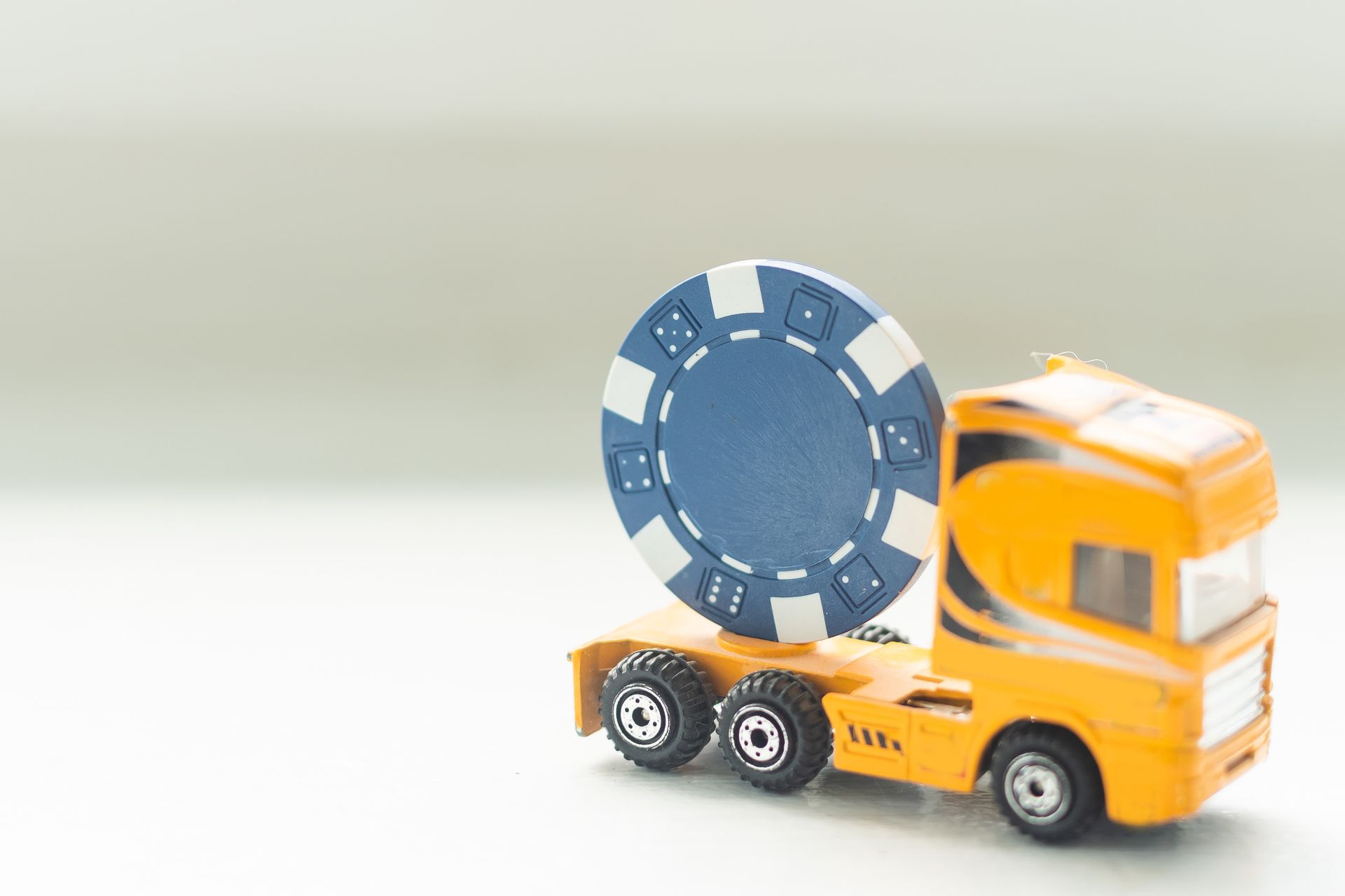 A toy truck with a poker chip on white background. A toy truck with a poker chip on white background.