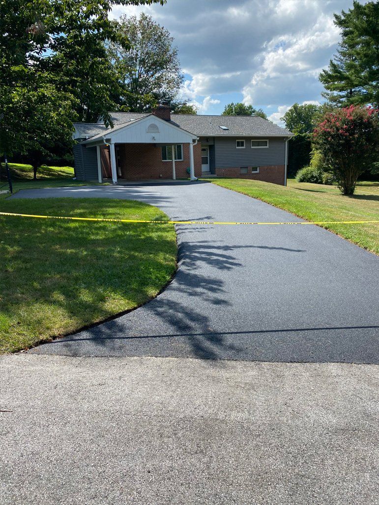 A brick house with a driveway leading to it