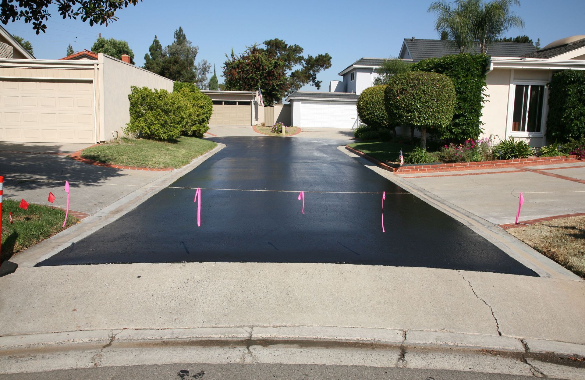 A residential driveway with pink markers on it