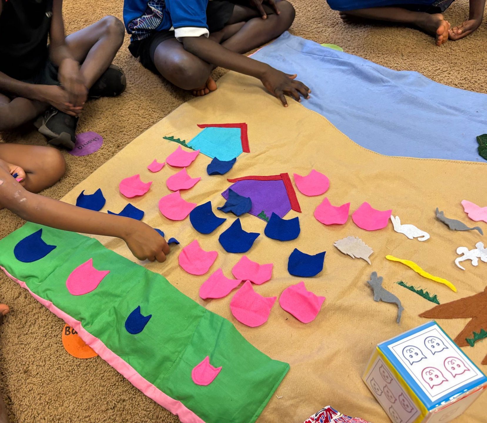 A group of kids playing an education game with pieces of felt