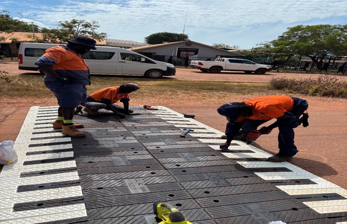 Three men working on installing a speed bump.