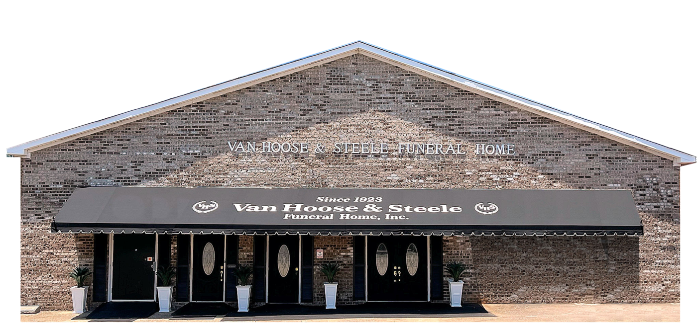 Front view of a brick storefront with a black awning and glass entrance doors
