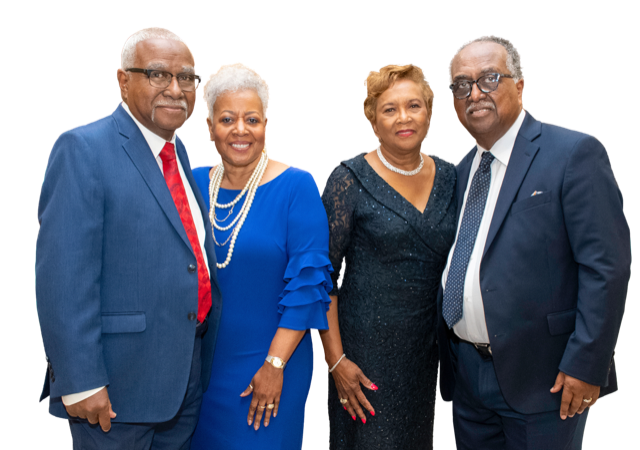 Four adults posing together in formal attire against a white background.