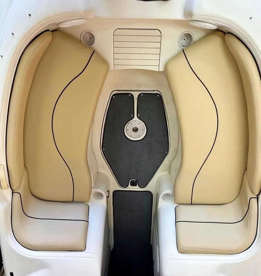 The inside of a white boat with tan seats
