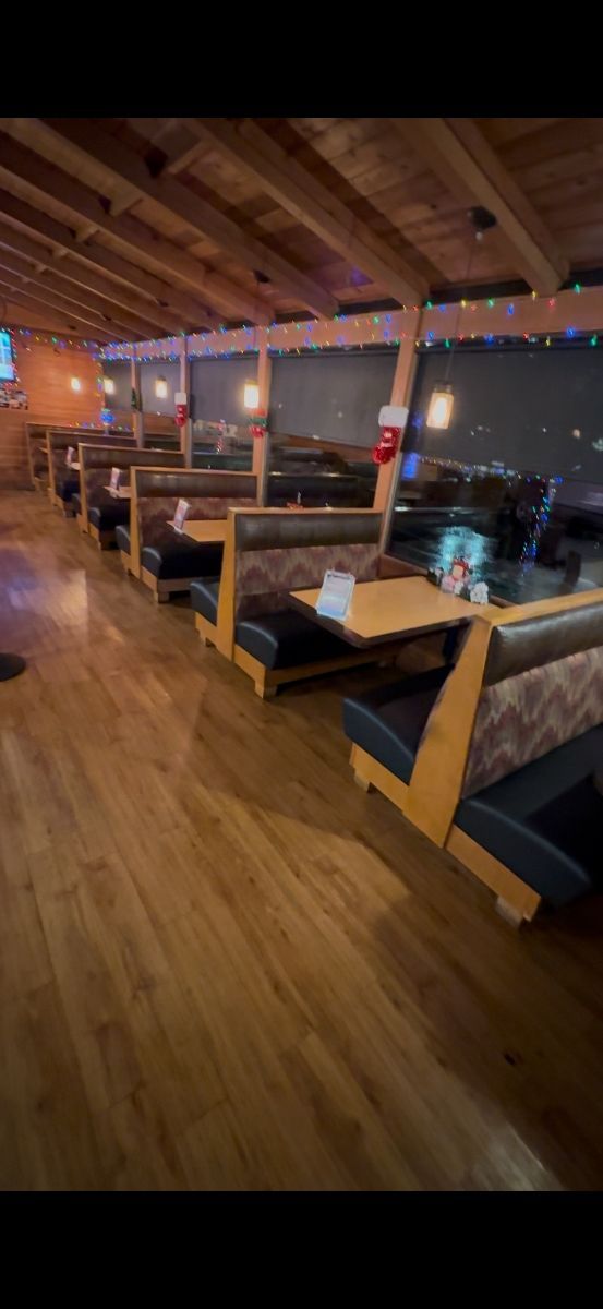 A row of booths in a restaurant with wooden floors.