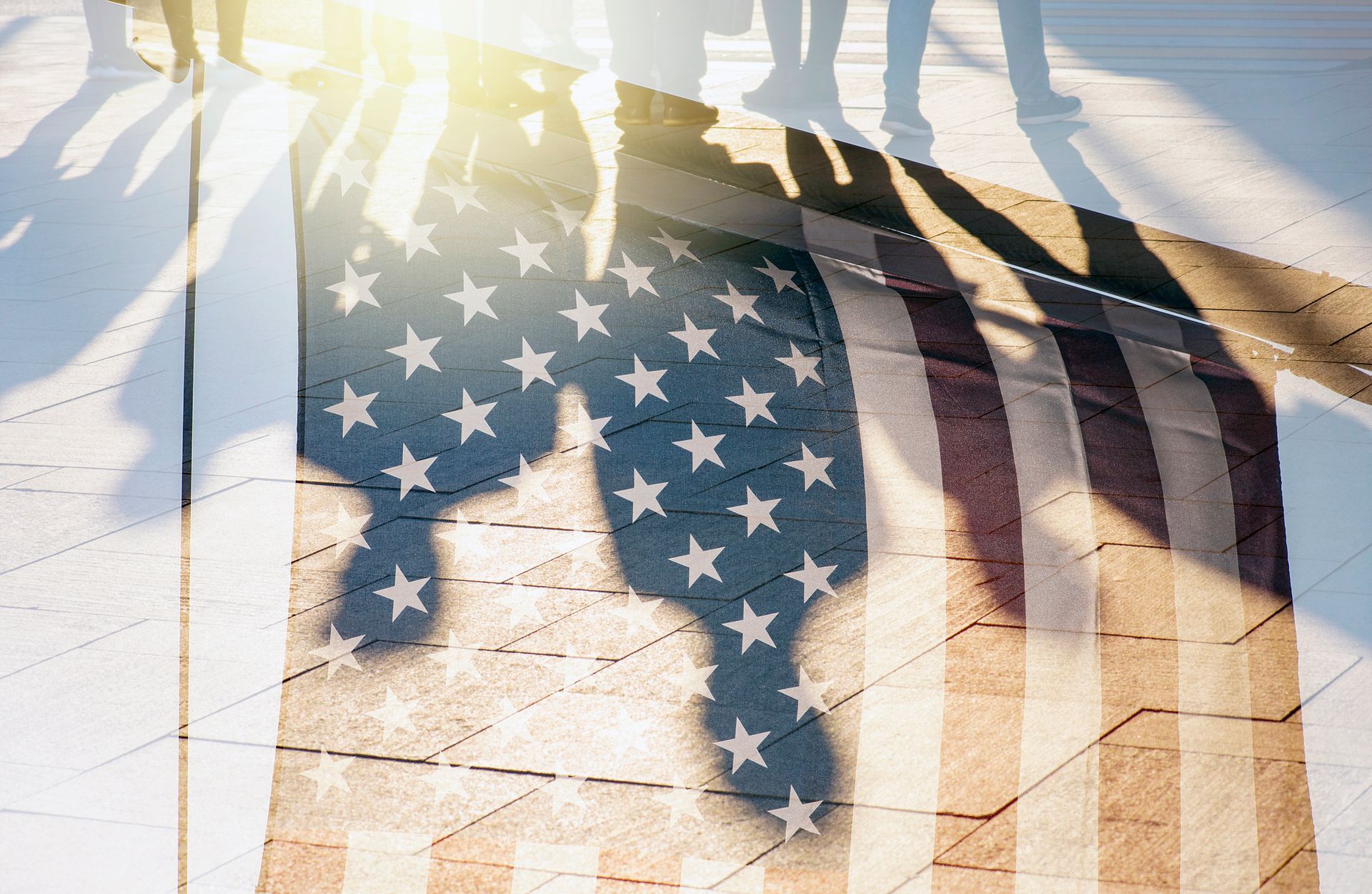 A group of people are standing in front of an american flag.