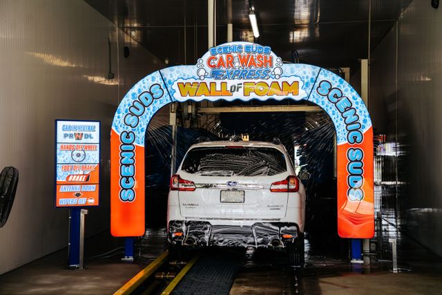 A white car is going through a car wash.