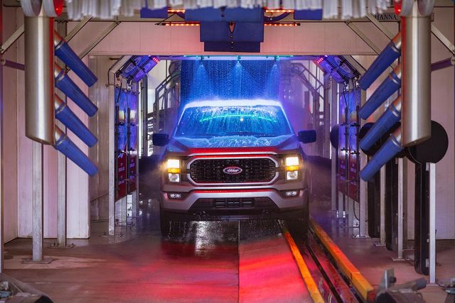 A red truck is going through a car wash.