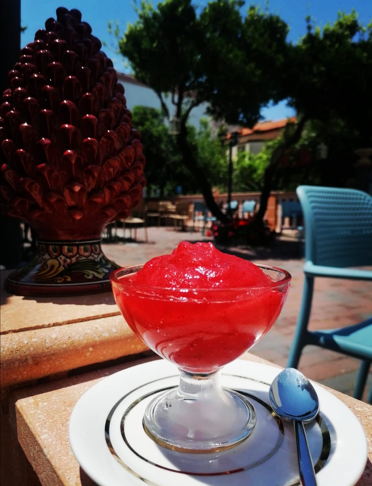 Una ciotola di gelatina rossa con un cucchiaio su un piatto