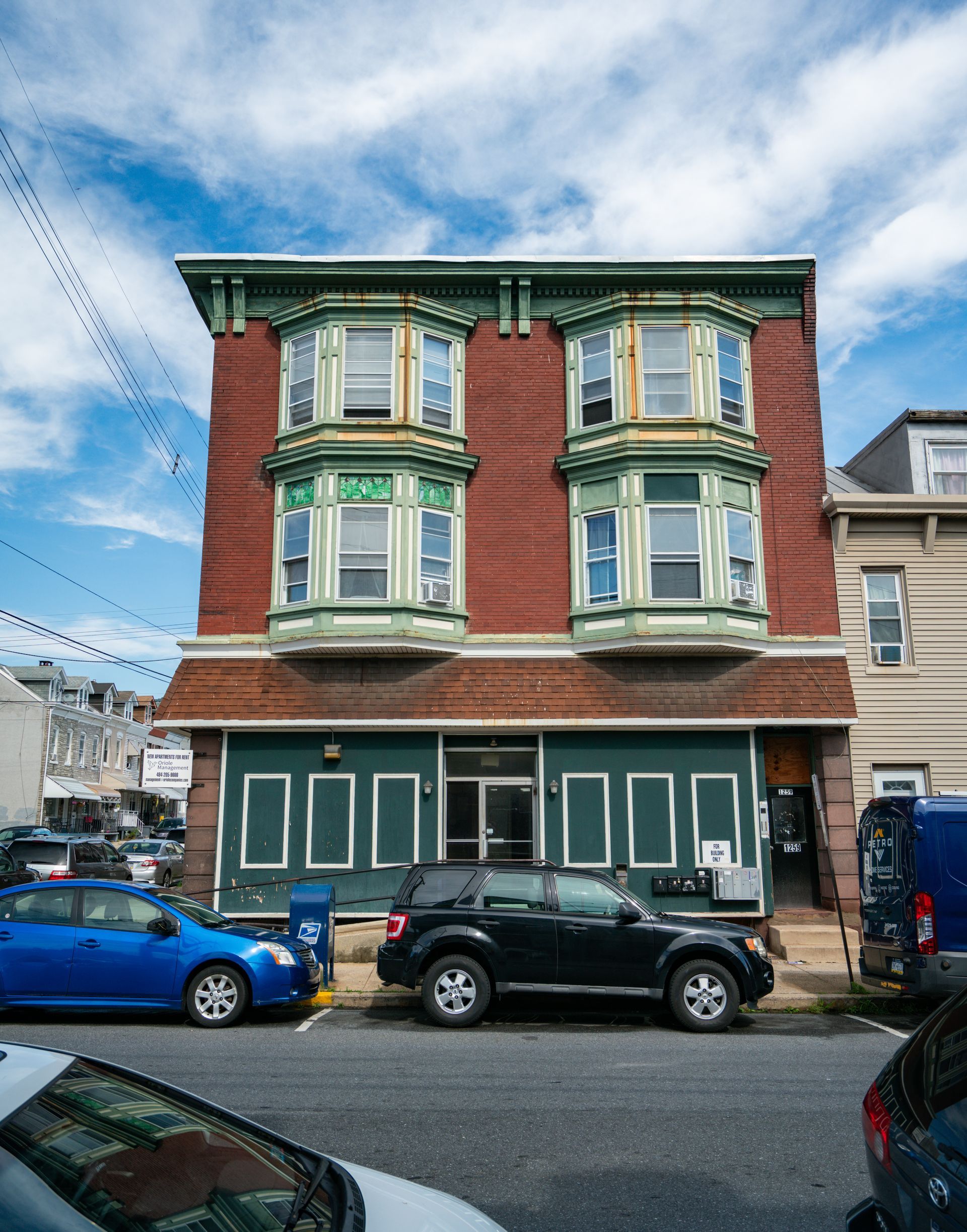 Photo of a 3 story building, seen from across the street.
