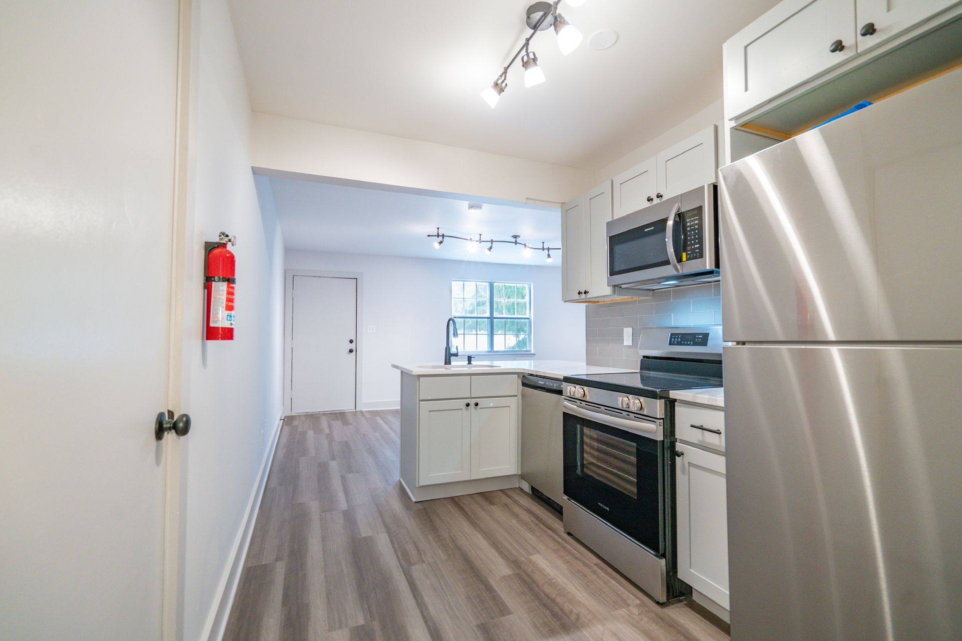 Photo of a kitchen with stainless steel appliances and the living room in the background