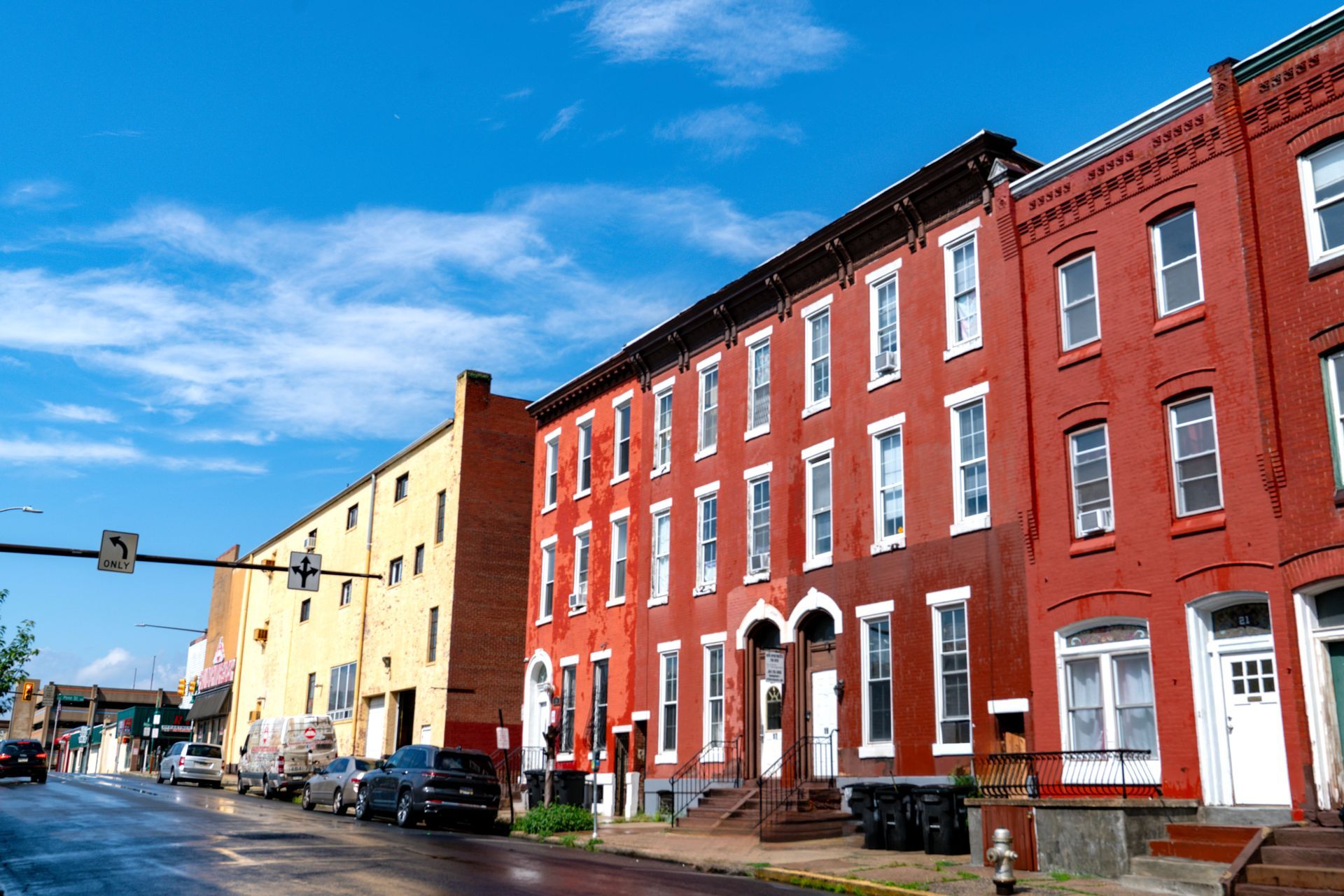 Photo of two buildings, with the main one being red brick, 3 stories and featuring a lot of windows