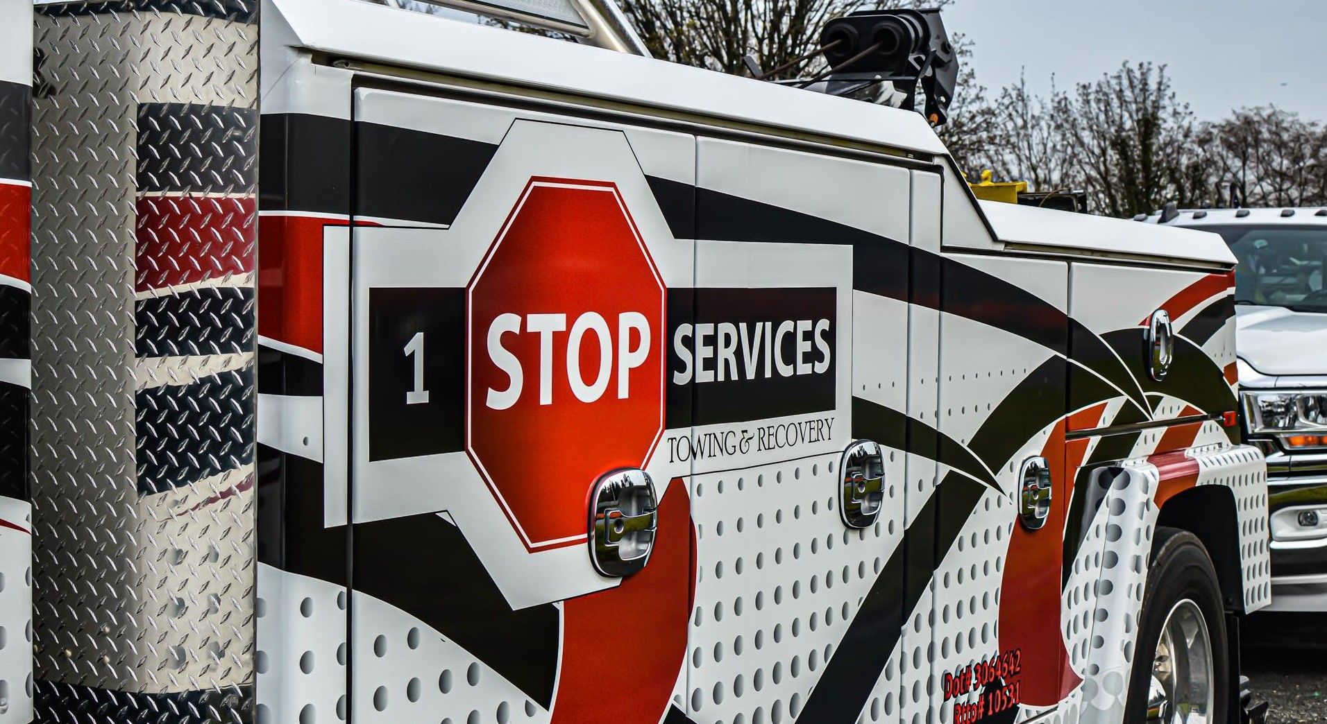 A tow truck with a stop sign on the side is parked in a parking lot.