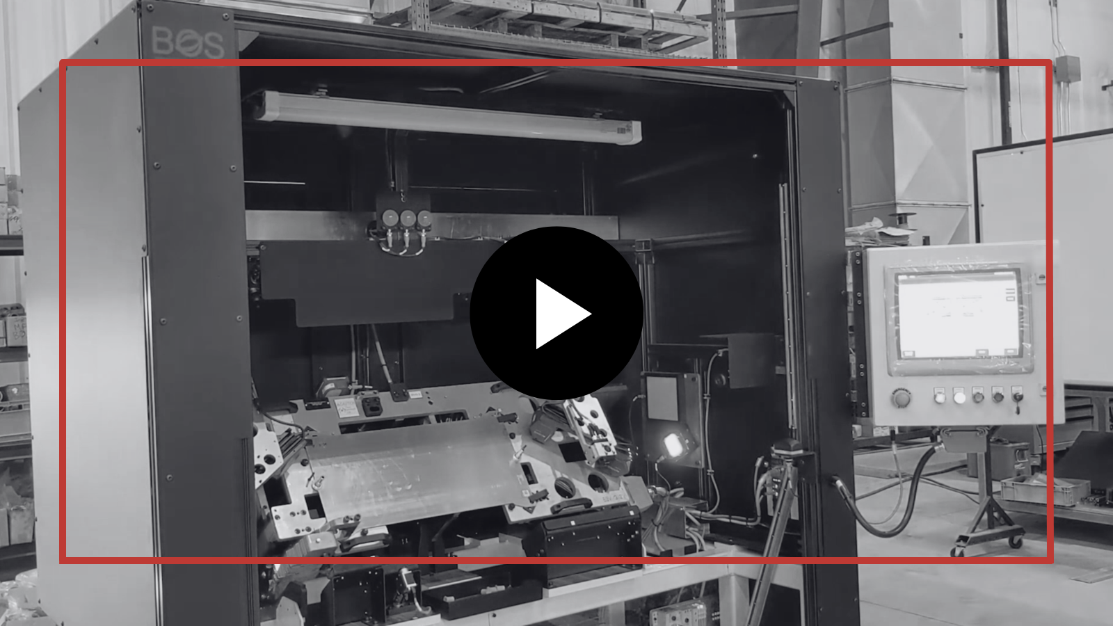 Industrial machine test chamber with a damaged vehicle inside, outlined by a red box and a monitor on the right.