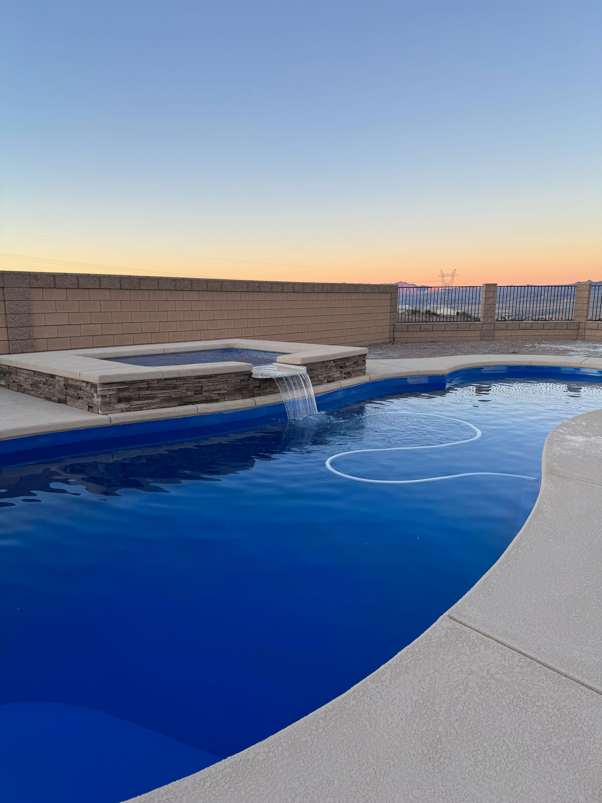 A large swimming pool with a waterfall in the middle of it.
