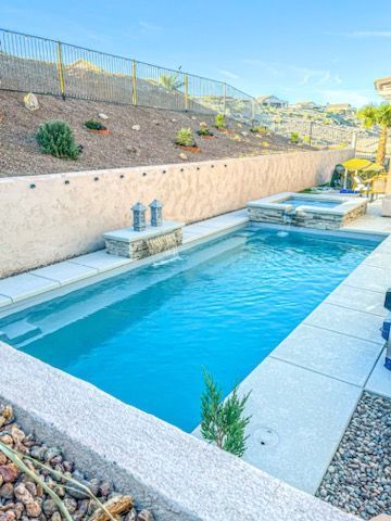 There is a large swimming pool in the backyard of a house.