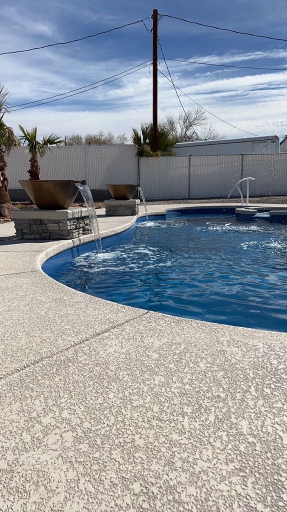 A large swimming pool with a fountain in the middle of it.