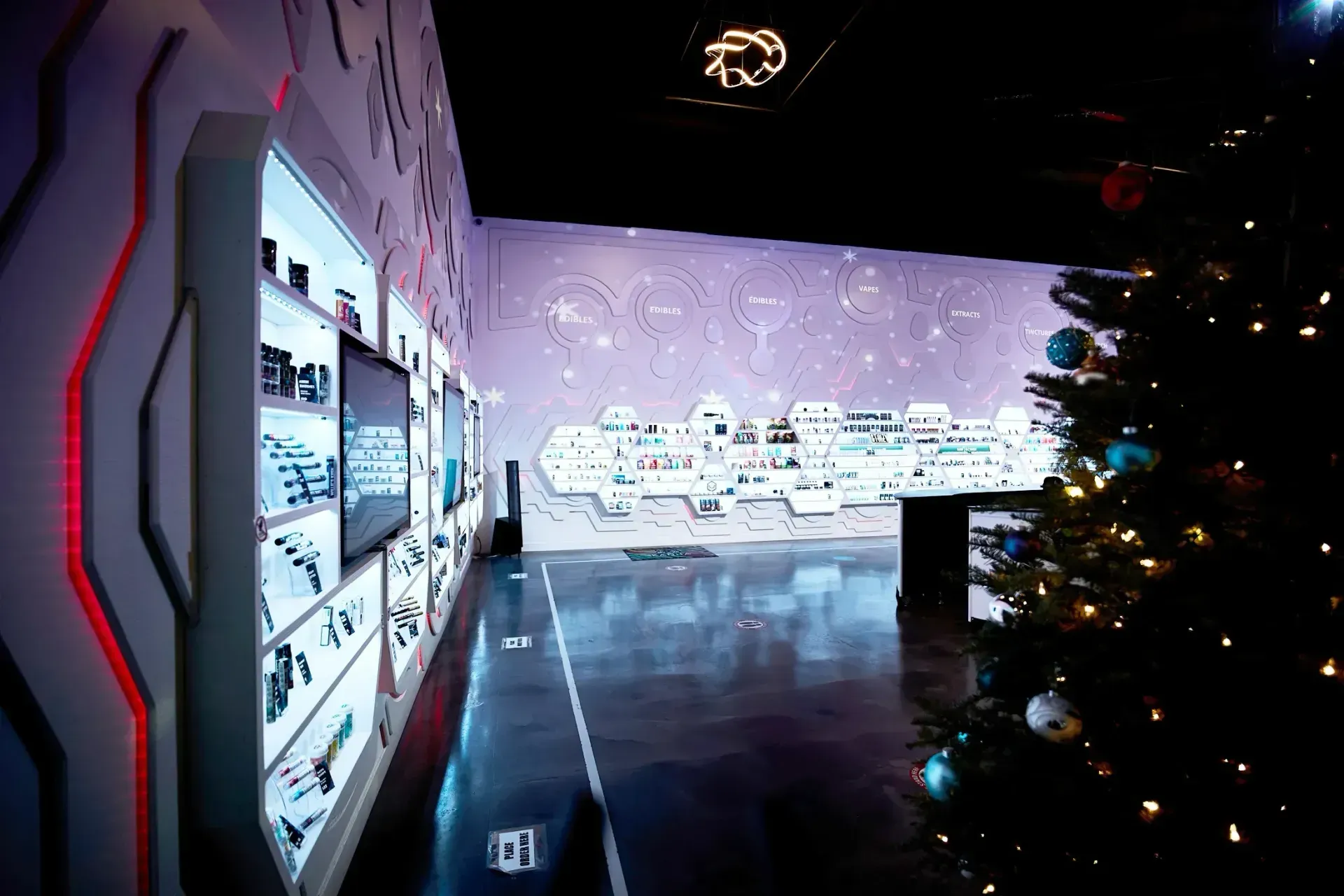 The store floor at Doobie Nights, with a large Christmas tree in the center and winter snowflakes on the walls. 